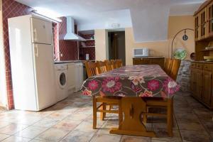 a kitchen with a dining table and a refrigerator at Casa rural con jacuzzi in La Parrilla