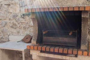 a stone fireplace with a bench next to a stone wall at Casa rural con jacuzzi in La Parrilla