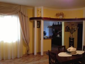 uma sala de jantar com uma mesa e uma cozinha com paredes amarelas em Villa Ortensia, villa in Alto Salento em Torre Ovo