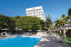 einen Pool mit Stühlen und Sonnenschirmen vor einem Hotel in der Unterkunft Hotel Riu Festival in Playa de Palma