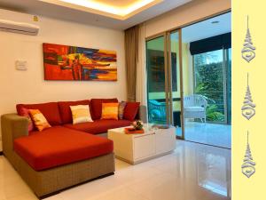 a living room with a red couch and a painting at Apt S104 Kamala Regent in Kamala Beach