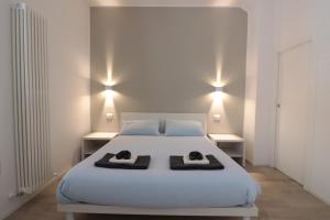 a bedroom with a white bed with two towels on it at Moon Bologna in Bologna