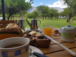 einen Tisch mit Brot und Kaffee und eine Tasse Orangensaft in der Unterkunft Fincas del Huacle in Nono
