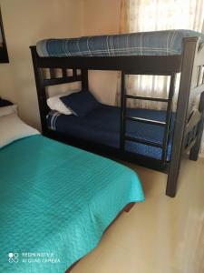 a room with two bunk beds and a bed at Sueños Vividos Hospedaje in Sogamoso