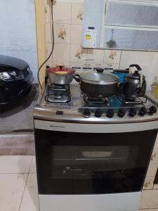 two pots and pans sitting on top of a stove at Casa Livramento Rivera diária in Santana do Livramento