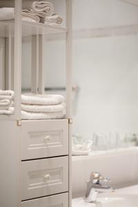 a white bathroom with a sink and towels at Hotel Schwalbe in Vienna