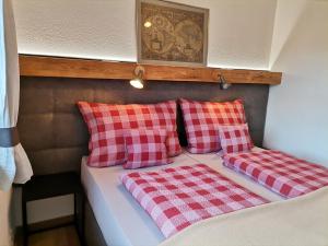 uma cama com almofadas vermelhas e brancas em Ferienhaus Weber-Häusl em Reith im Alpbachtal