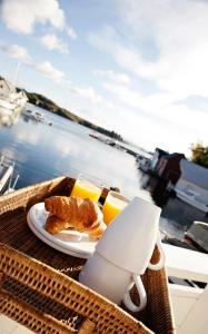 una mesa con un plato de cruasanes y zumo de naranja en Marthas Rorbu en Bakkasund