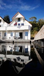una casa blanca con su reflejo en un cuerpo de agua en Marthas Rorbu en Bakkasund