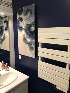 La salle de bains est pourvue d'un lavabo et d'un miroir. dans l'établissement Appartement Cosy, tout confort, à deux pas de la mer, à Deauville