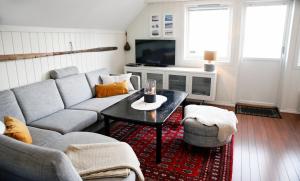ein Wohnzimmer mit Sofa und Tisch in der Unterkunft Marthas Rorbu in Bakkasund