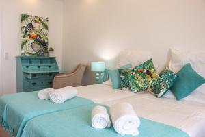Un dormitorio con dos camas con toallas encima. en Apartamentos SweetHomes, en Faro