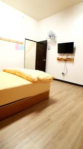 潮州鎮的住宿－得恩典旅宿 ，一间卧室配有一张带镜子的床和风扇