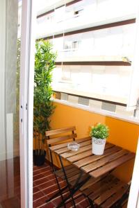 un banco de madera en un balcón con ventana en Apartamentos SweetHomes, en Faro