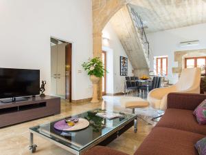 a living room with a couch and a tv at Town House Esglesia in Alcudia in Alcudia