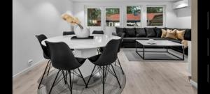 salon z białym stołem i czarnymi krzesłami w obiekcie Hytte med 4 Soverom w mieście Kristiansand