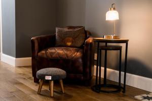 a brown chair sitting next to a table with a lamp at Courtyard at Crail in Crail