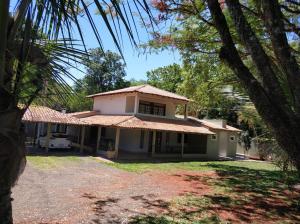 een wit huis met een dak bij Pousada Falls Park in Foz do Iguaçu