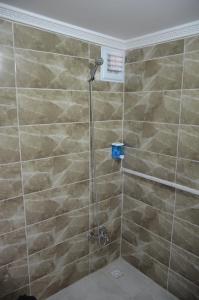 a bathroom with a shower with brown tiles at TABRİZ HOTEL in Istanbul
