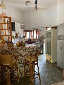 een keuken met een tafel en stoelen en een koelkast bij Residência Guarujá Praia Pernambuco Condomínio Fechado in Sao Paulo