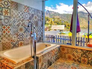 y baño con bañera y ventana. en TIBERIAS by luxury Atitlan, en San Pedro La Laguna