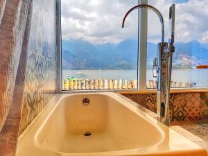 y baño con bañera y ventana. en TIBERIAS by luxury Atitlan, en San Pedro La Laguna