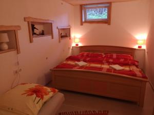 een slaapkamer met een bed met rode lakens en een raam bij chalupa samo in Lúčky
