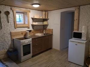 a small kitchen with a stove and a microwave at privatno117 in Lúčky