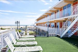 a row of white chairs on the balcony of a hotel at Granada Ocean Resort in Wildwood Crest
