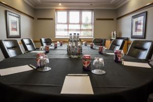 - une longue table dans une pièce avec des chaises et des canettes de soda dans l'établissement Holiday Inn Manchester West, an IHG Hotel, à Manchester