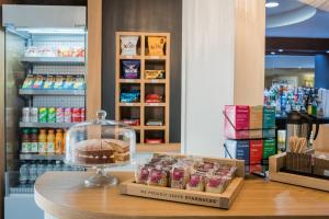 a bakery with a display of food on a counter at Holiday Inn Manchester West, an IHG Hotel in Manchester