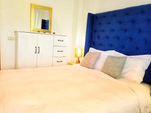 een slaapkamer met een groot bed met een blauw hoofdeinde bij VENICE by luxury Atitlan in San Pedro La Laguna