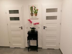 una habitación con 2 puertas y una mesa con flores en Mieszkanie Konin Zatorze, en Konin