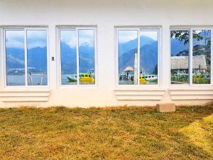 a house with windows with a view of the water at VENICE by luxury Atitlan in San Pedro La Laguna