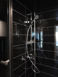 a shower with a shower head in a bathroom at Black Hotel in Kempele +44 photos