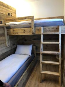 two bunk beds in a room with a ladder at Casa Cecilia in Bormio