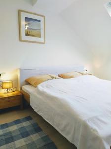 a bedroom with a white bed with a picture on the wall at Super Wohnungen #2, #3 und #4 DG im Zentrum, Süd-Sonne und Burg-Blick in Stolberg