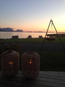 a sunset with two vases and a swing at TINEBUA Basecamp Senja in Berg