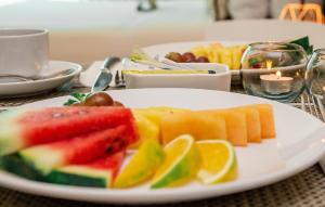 a white plate with fruit on a table at Hotel Santa Cecilia B&B in Cartagena de Indias