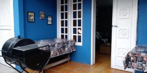um quarto com uma parede azul e um quarto com uma tábua de engomar em Casa Praia dos Anjos - 50m da praia em Arraial do Cabo
