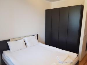 un letto con 2 cuscini e una testiera nera di Borovets Gardens Apartments TMF a Borovets