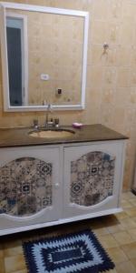 um banheiro com uma pia e um espelho em Casa Praia dos Anjos - 50m da praia em Arraial do Cabo