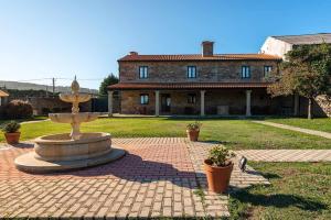 fontanna przed dużym domem w obiekcie Hotel - Casa de Turismo Rural Dugium w mieście Fisterra