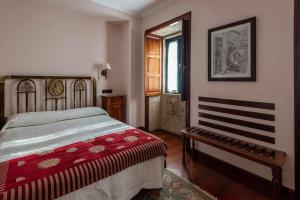 sypialnia z łóżkiem i ławką w obiekcie Hotel - Casa de Turismo Rural Dugium w mieście Fisterra