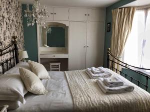 a bedroom with a bed with towels on it at Oriel Cottage, Aldeburgh in Aldeburgh