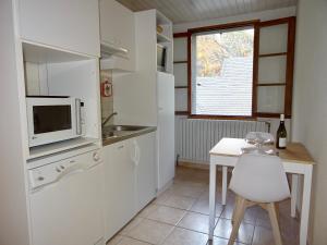 uma pequena cozinha com uma mesa e um micro-ondas em Les Oulles em La Chapelle-en-Valgodemard