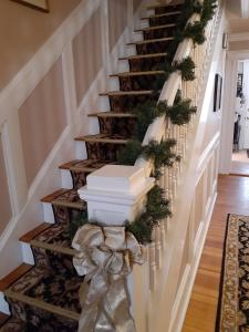 un escalier avec des décorations de Noël et un bow dans l'établissement The Victoria Inn Bed & Breakfast, à Hampton Beach