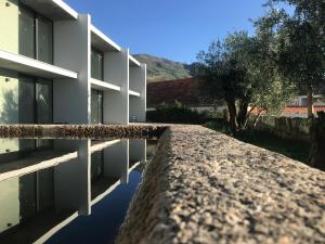 um edif�cio com uma parede de pedra ao lado de uma �rvore em Pena D'�gua Boutique Hotel & Villas na Covilh�