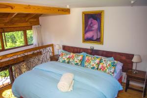 een slaapkamer met een blauw bed en een houten hoofdeinde bij Celestial Inn in Pucón