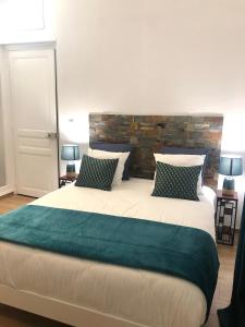 a bedroom with a large bed with a brick wall at Ginkgo Maison d'hôtes in Amiens